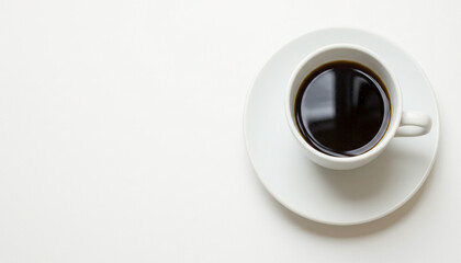 White cup of black coffee on white saucer in minimalist composition with clean design and stark contrast suitable for modern coffee photography and artistic beverage presentation
