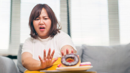 Attractive, chubby teenage girl refuses to eat sweet donuts because they are added sugar and not...