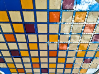 Colorful checkered roof covering the sky with clouds passing by