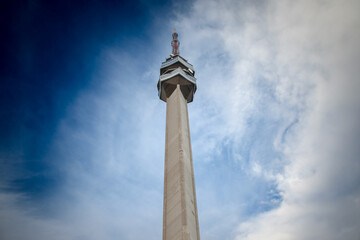 Obraz premium A towering view of the Avala Tower’s concrete structure near Belgrade, Serbia, captured from below against a softly lit sky. It is a TV tower & broadcasting antenna in the suburbs of Belgrade, Serbia.