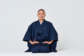 正座をする紺色の着物姿のシニア男性 © One
