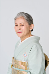 淡い緑の着物姿の笑顔のシニア女性