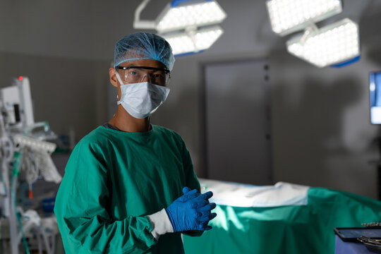 Surgeon in operating room wearing protective gear, preparing for surgery, copy space - Powered by Adobe