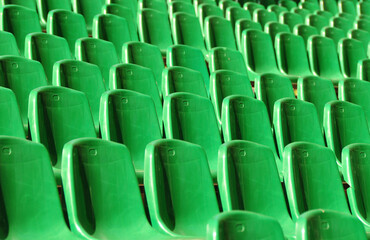 Naklejka premium rows of vibrant green seats in a stadium, arranged in a neat and orderly pattern