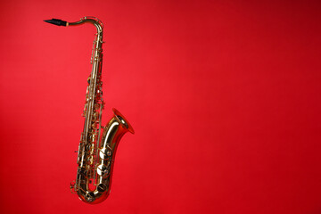 Jazz. One beautiful saxophone on red background, space for text