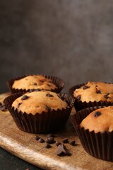 Delicious muffin with chocolate chips on table, closeup
