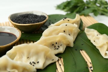 Tasty boiled gyoza (dumplings) served on white table, closeup