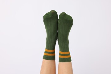 Woman wearing green socks on white background, closeup