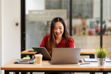 Asian Business woman using calculator and laptop for doing math finance on an office desk, tax, report, accounting, statistics, and analytical research concept
