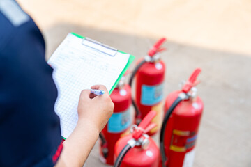 A safety officer is performing the monthly fire extinguisher inspection.