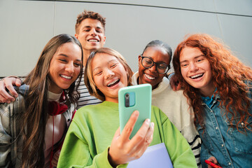 Joyful group of teenagers enjoying a delightful moment together while sharing laughter and...