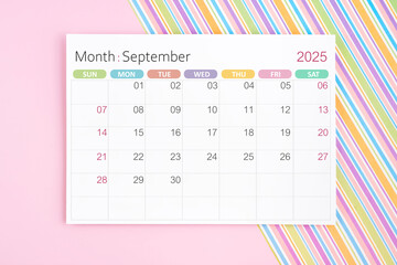 September 2025 calendar page on pink and rainbow background.