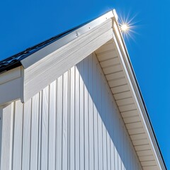 Obraz premium Sunlight Glints Off Pristine White uPVC Soffit and Vertical Siding Creating a Stunning Contrast Against Blue Sky