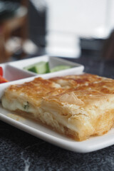 Delicious turkish borek served with fresh vegetables at a cafe
