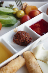 Delicious assortment of fresh vegetables and sauces on a white plate