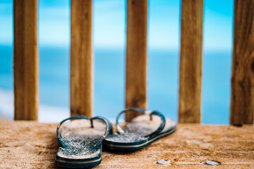 Sandy Flip-Flops Near Ocean Lookout at Sunset