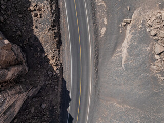 Aerial view of a road cutting through barren terrain in daylight