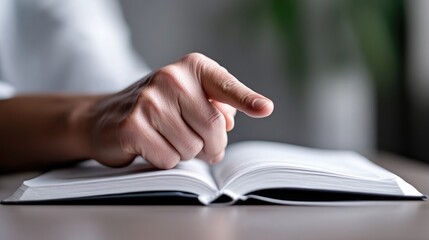 Close-up of a person reading a book, finger pointing at text