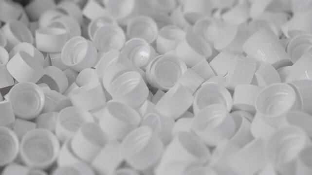 White plastic bottle caps. Production of liquid in plastic bottles. Plastic recycling plant. Production of plastic bottles and caps.