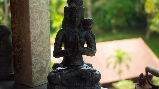 An old hindu stone statue of the Bodhisattva Devi Tara sitting  on the street on the Bali
