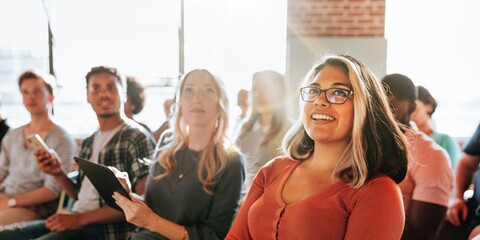 Diverse group of people, including a smiling woman, attending seminar. The seminar audience...