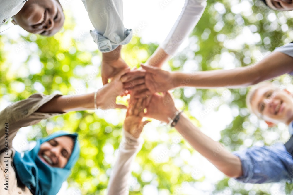 Poster diverse group of people joining hands in a circle, symbolizing teamwork and unity. outdoor setting w