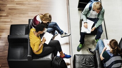 Group of students studying together. Diverse students, male and female, engaged in studying. Students with books and notes, focused on their studies in a casual setting. Casual students at school.
