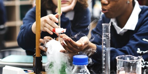 Students in science lab conduct experiment. Diverse students study science in school lab. Students focus on science experiment at school. Diverse students in science class conduct experiment