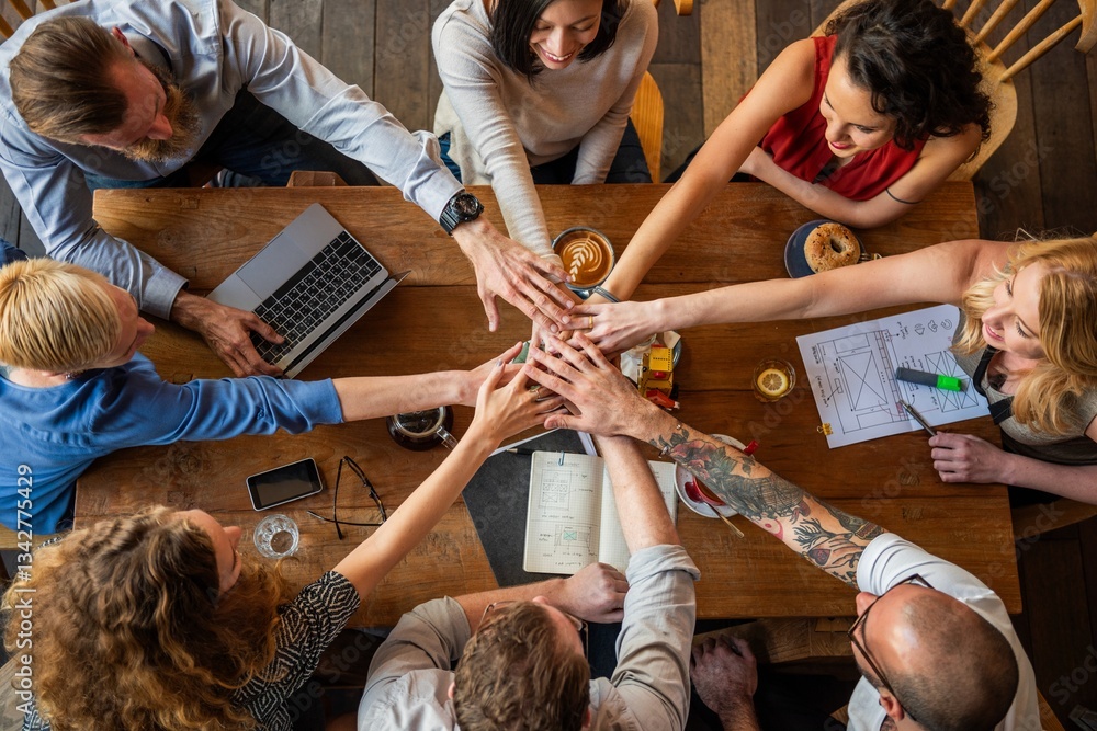 Aufkleber diverse group of people around a table, hands together in unity. teamwork, collaboration, and unity 