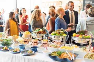 Buffet table with variety dishes at a social event. Happy diverse people chatting and socializing,...