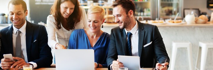 Group of professionals in a meeting, discussing work. Diverse team collaborating, using laptops and tablets. Business attire, teamwork, office setting. Business corporate group teamwork.
