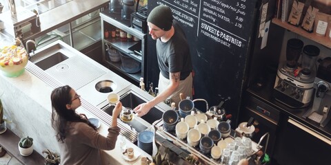 A barista serves coffee to a customer in a cozy cafe. The cafe is bustling with activity, coffee cups stacked, and a menu board displaying options. Warm cafe atmosphere. Barista working at cafe.