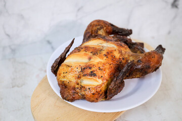 Roasted chicken whole on white plate