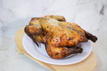 Roasted chicken whole on white plate