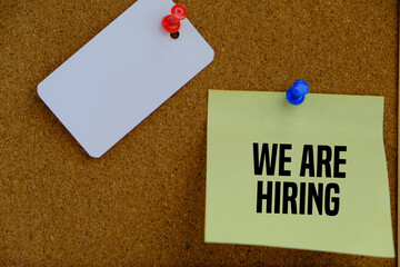 we are hiring text on yellow paper as a hiring and job searching concept on the notice board