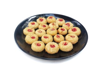 Nastar cake with strawberry jam on top on black plate isolated on white background 