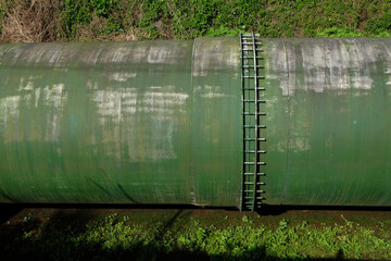 Connections on large pipes for water supply to power plants.Large green iron pipes.Power energy...