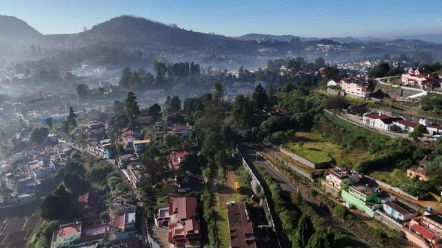 The Nilgiri Mountain Railway chugging through lush green valleys with houses