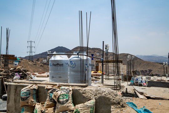 Two Farplast water tanks on top of a house that is under construcion in a pablano favela informal housing neighborhood in Rimac, Lima, Peru