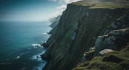 Majestic coastal cliffs overlooking a serene ocean under a cloudy sky
