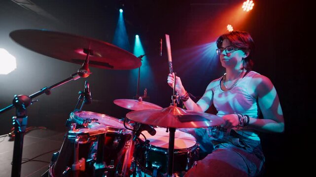 Female drummer performing energetically on stage in slow motion
