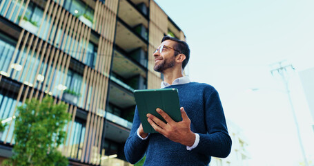 Fototapeta premium Thinking, businessman and research with tablet in city, realtor and project for property development. Below, real estate agent and inspiration with smile for online review, listing website or walking