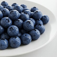 closeup of fresh blueberries on a white plate with water droplets on their surface