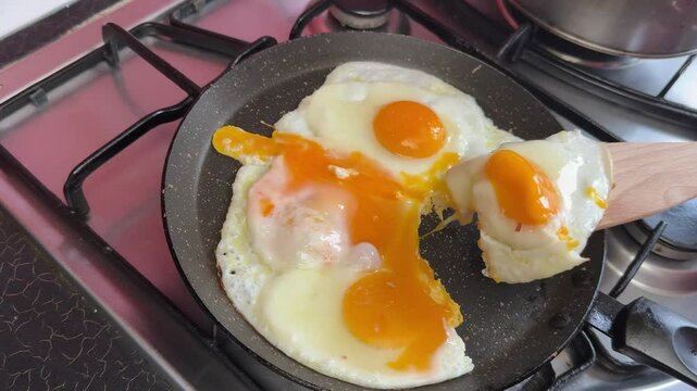 take an egg from the frying pan with a spatula Failed attempt to flip a sunny side up