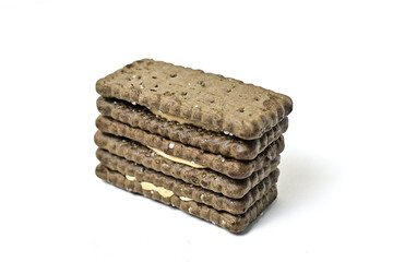 Photo of 3 or three black biscuit with peanut cream and sugar on the topping isolated on white background. Stack.