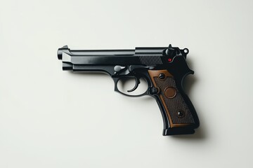 A black pistol laying flat on a plain white surface