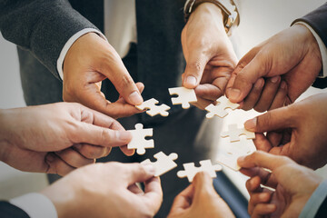 The concept of teamwork and partnership. Businessman's hands putting together puzzle pieces in the office and join together in a jigsaw puzzle team. Charity. Volunteers. Business unity as a team.