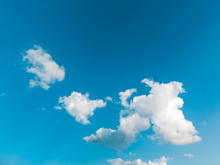 white clouds drift across a bright blue summer sky