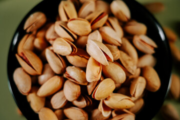 Pistachios in a black bowl highlighting their texture and natural colors during a casual snack setting