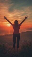 Fototapeta premium Silhouette of a woman with arms raised, overlooking a vibrant sunset above the ocean, embracing tranquility and freedom.